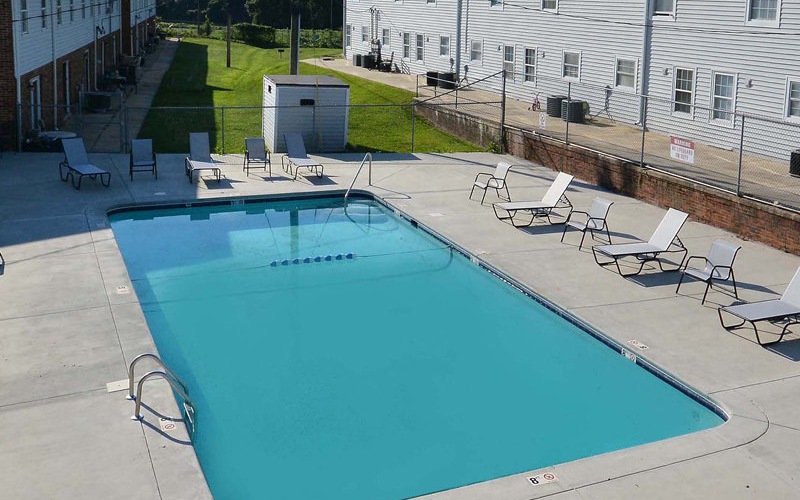 large, outdoor swimming pool flanked by lounge chairs